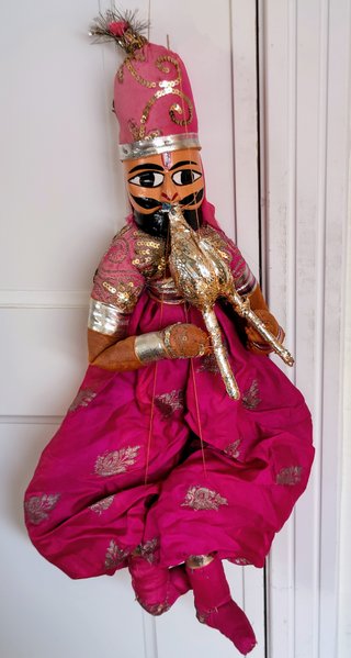 Marioneta de tela rosa con traje tradicional