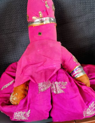 Marioneta de tela rosa con traje tradicional