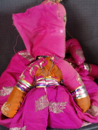 Marioneta de tela rosa con traje tradicional