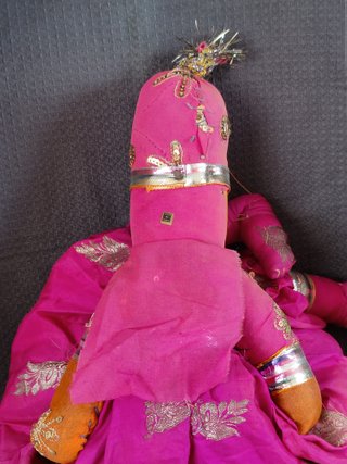 Marioneta de tela rosa con traje tradicional