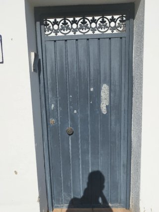 Puerta de garaje metálica gris y puerta de entrada