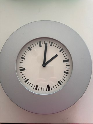 Reloj de pared plateado y blanco