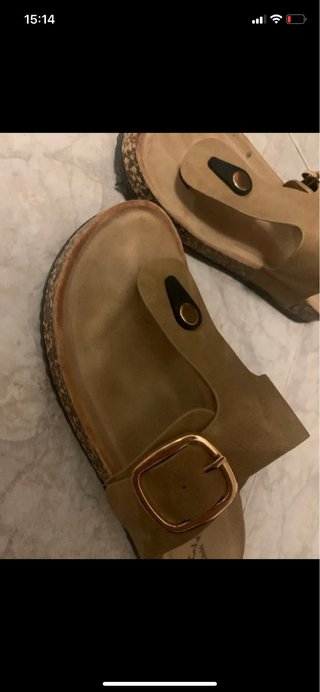 Sandalias de verano beige con hebilla dorada.