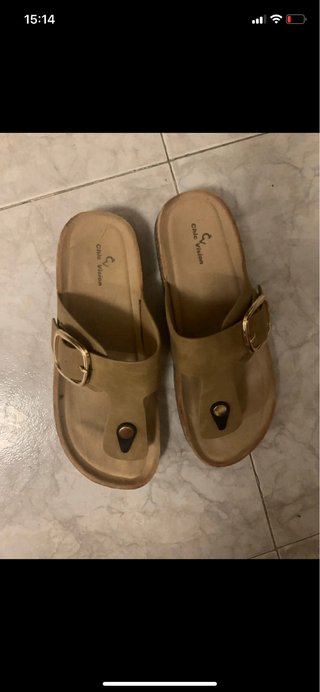 Sandalias de verano beige con hebilla dorada.