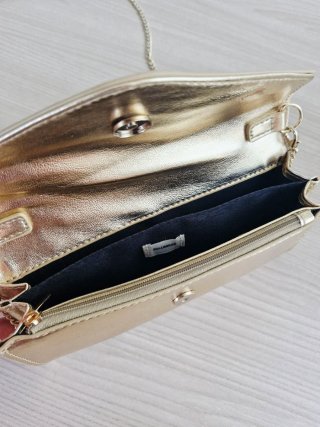 Bolso de mano dorado con cadena