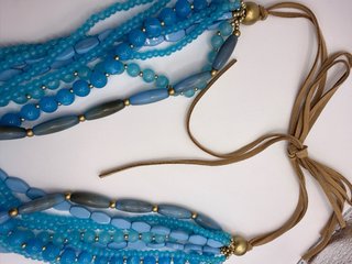 Collar boho multicapa en tonos azules con borlas
