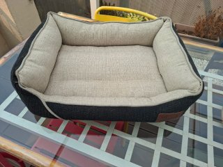 Cama para mascotas beige y negra