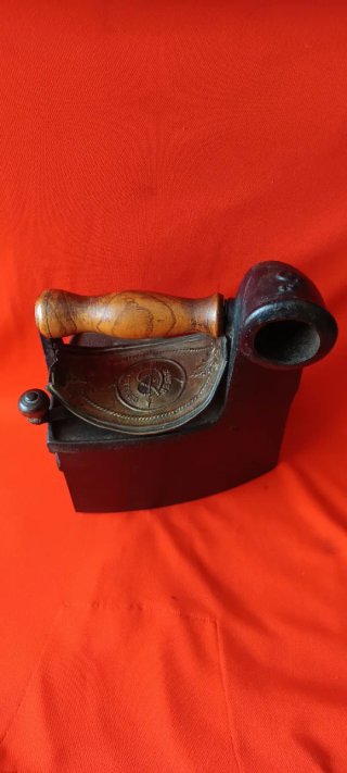Plancha antigua de hierro con chimenea
