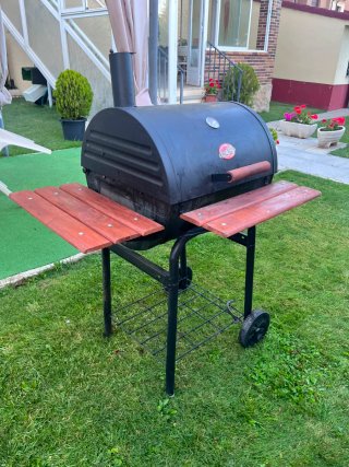 Barbacoa de carbón con mesas laterales