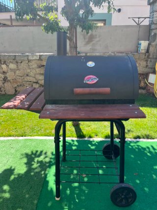 Barbacoa de carbón con mesas laterales