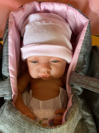 Carrito de bebé de juguete rosa y gris con bebé