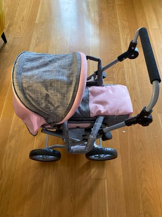 Carrito de bebé de juguete rosa y gris con bebé