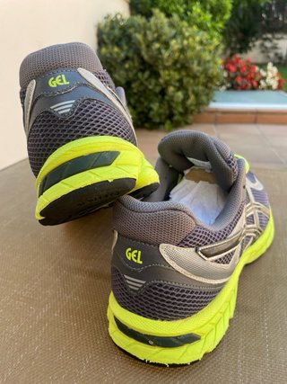 Zapatillas deportivas Asics gris y amarillo.
