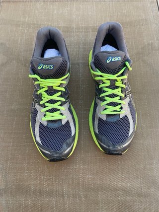 Zapatillas deportivas Asics gris y amarillo.