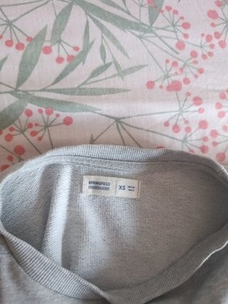 Sudadera gris con flores con falsa camisa debajo.