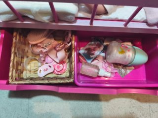 Cuna de muñeca rosa con accesorios y muñeca