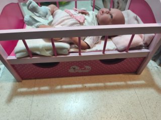 Cuna de muñeca rosa con accesorios y muñeca