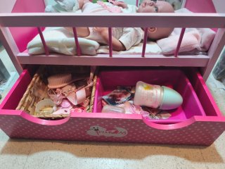 Cuna de muñeca rosa con accesorios y muñeca