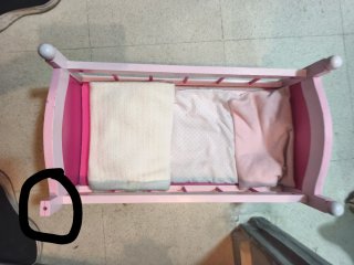 Cuna de muñeca rosa con accesorios y muñeca