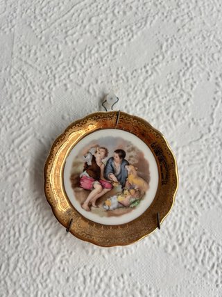 Plato decorativo dorado con escena