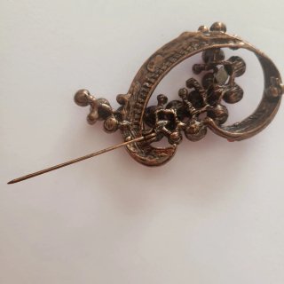 Broche rojo con cristales brillantes.