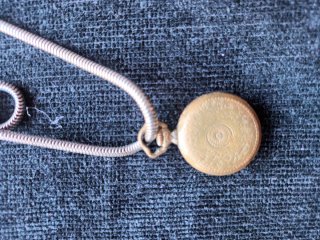 Reloj de bolsillo dorado con cadena