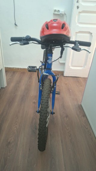 Bicicleta infantil azul con casco rojo