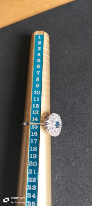 Anillo con piedra azul y detalles plateados