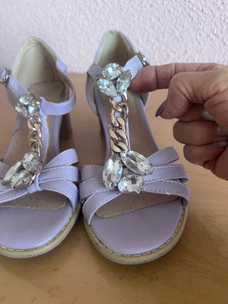 Sandalias lilas con pedrería y cadena.