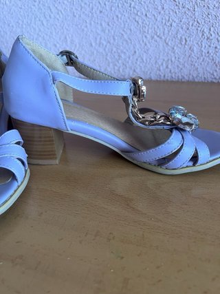 Sandalias lilas con pedrería y cadena.