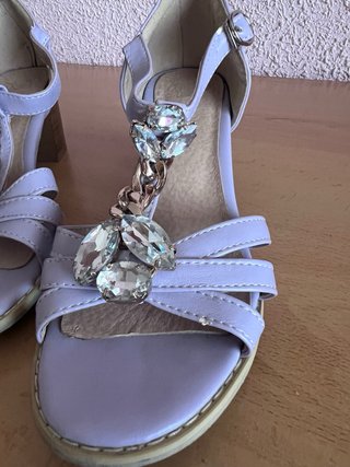 Sandalias lilas con pedrería y cadena.