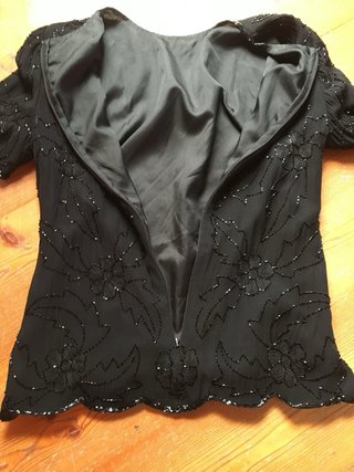 Blusa nera ricamata con perline.