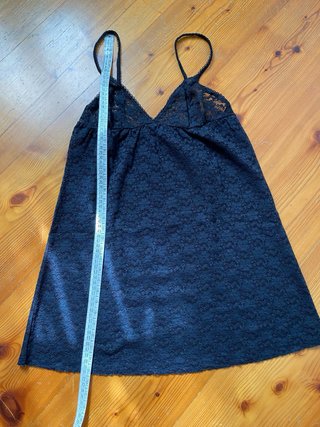 Canotta in pizzo nero con spalline regolabili.