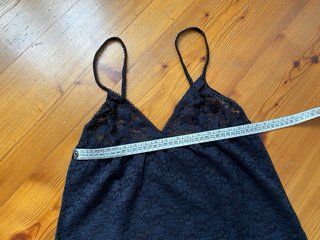 Canotta in pizzo nero con spalline regolabili.