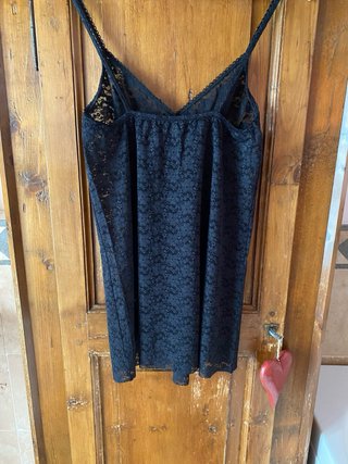 Canotta in pizzo nero con spalline regolabili.