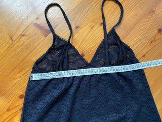 Canotta in pizzo nero con spalline regolabili.