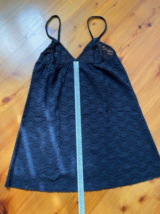 Canotta in pizzo nero con spalline regolabili.