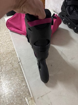 Patines en línea negros y bolsa de transporte rosa