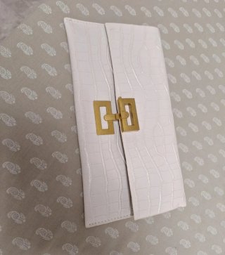 Cartera de mano blanca con cierre dorado