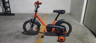 Bicicleta pedales y ruedines naranja para niño