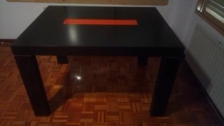 Mesa de salón negra con detalle naranja