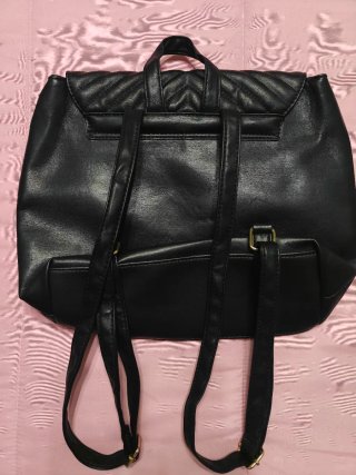 Mochila negra acolchada con hebillas doradas