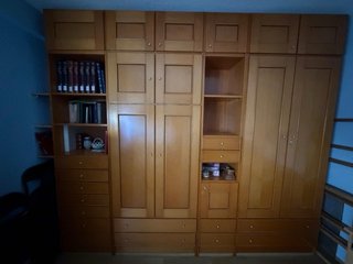 Mueble de madera con cama empotrada y armario. La