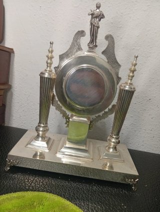 Reloj de sobremesa plateado con figura