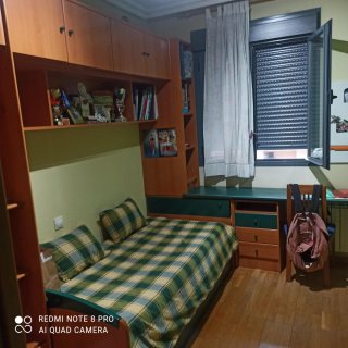 Dormitorio juvenil con estanterías y escritorio