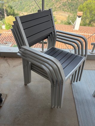 Mesa de exterior con cuatro sillas y una alfombra.