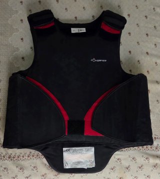 Pantalón montar negro, casco y chaleco equitación