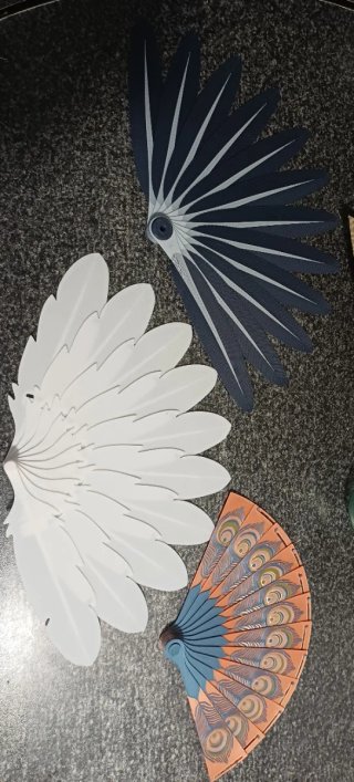 Abanicos de plumas blancos y abanico naranja