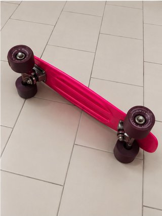Monopatín rosa con ruedas moradas