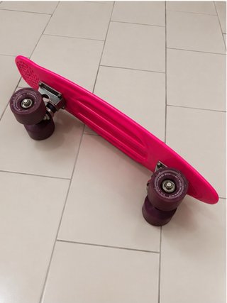 Monopatín rosa con ruedas moradas